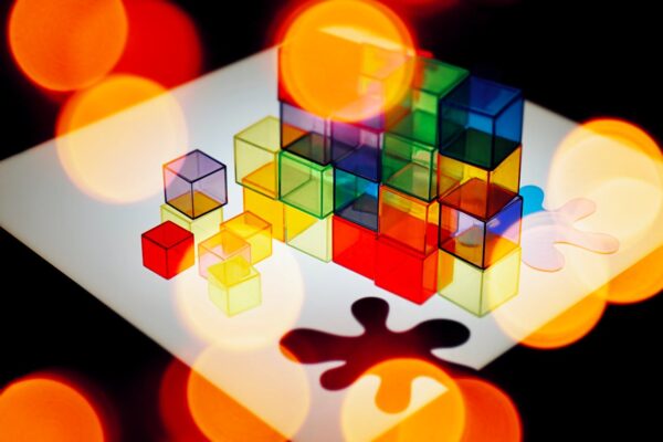 Colorful transparent cubes and abstract bokeh light create a vibrant geometric design.