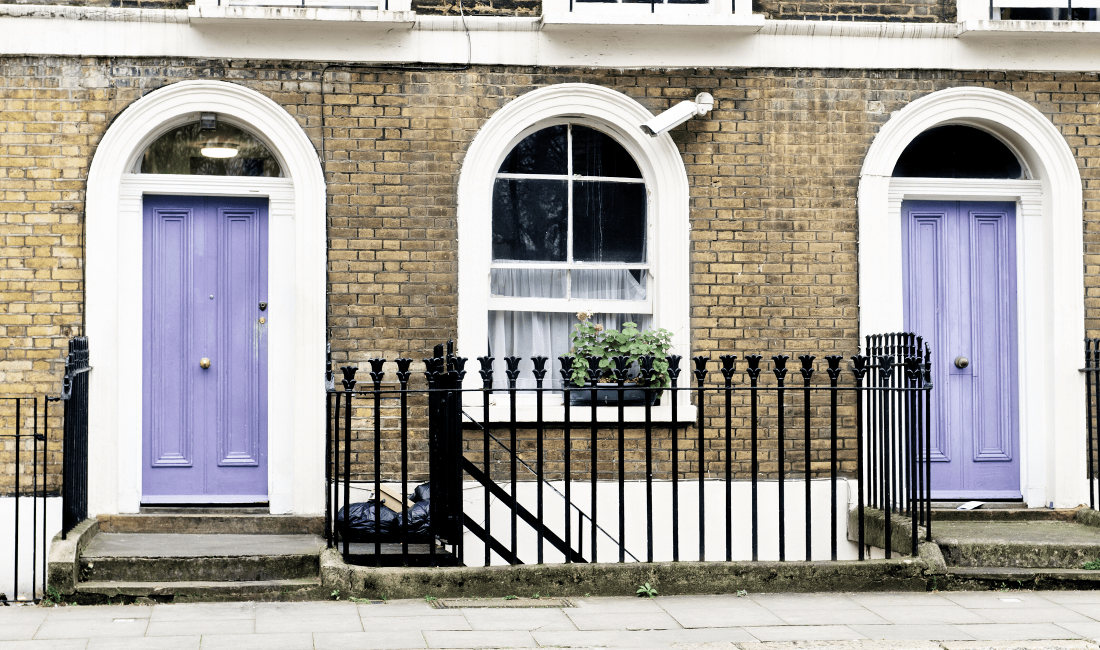 Two joined homes with light purple front doors.